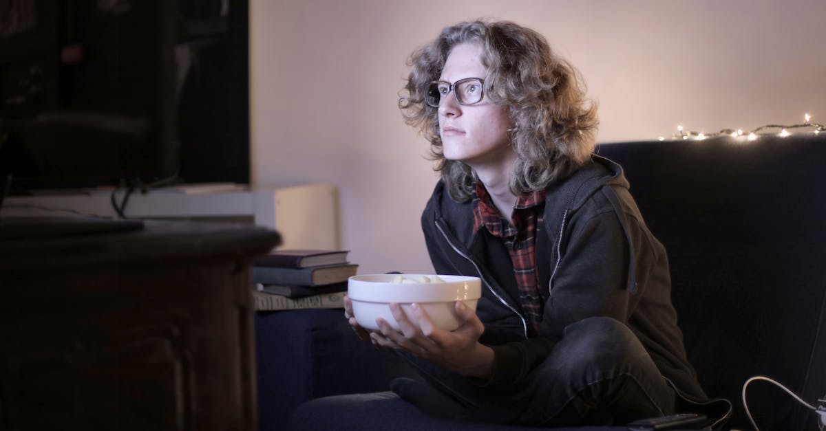 Person watching TV at home with a bowl of popcorn